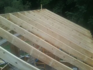 New roof rafters set over an addition before sheathing in Wolverton