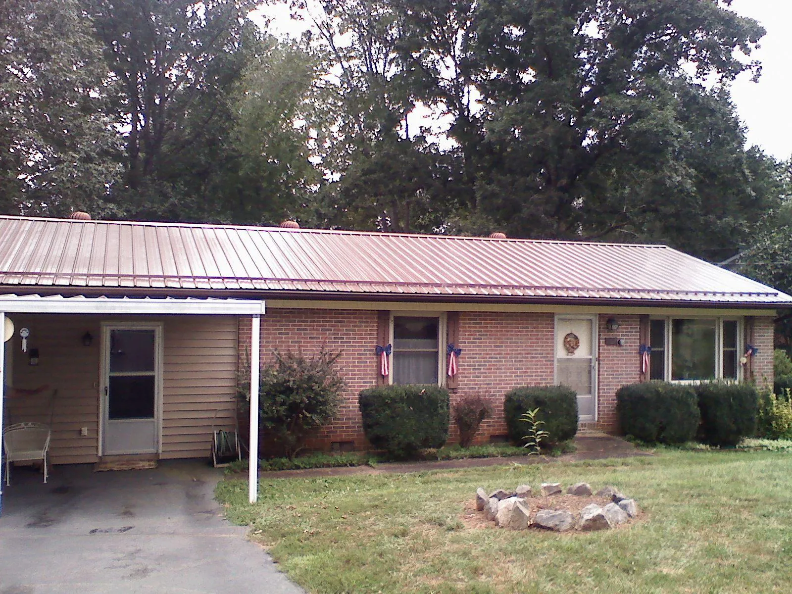 Bronze metal roof and carport on a brick ranch home — Roof Repair work by our crew in Wolverton