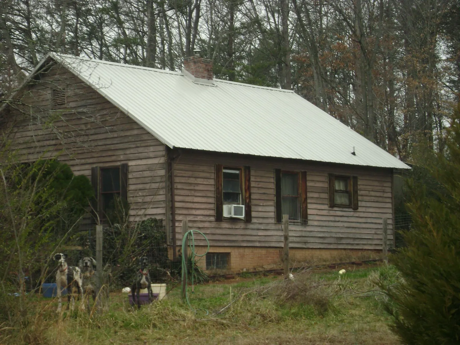 White metal roof on an old wood sided farmhouse, from a Metal Roof Installation job in Wolverton